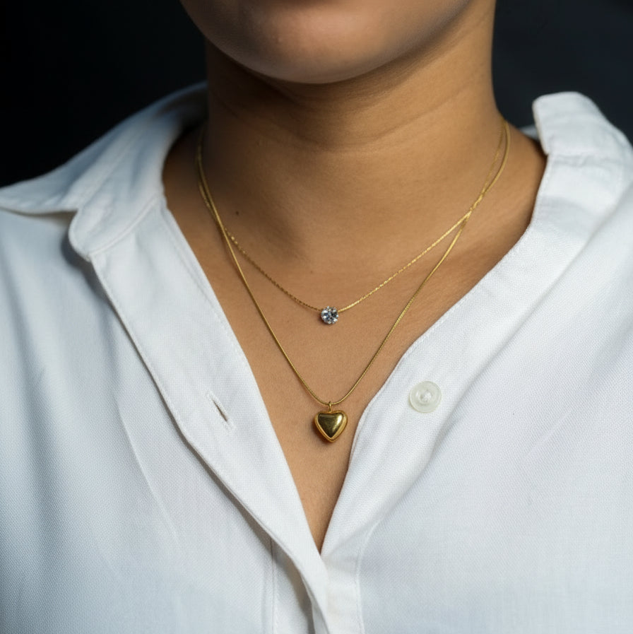 Person wearing a white shirt with gold necklaces